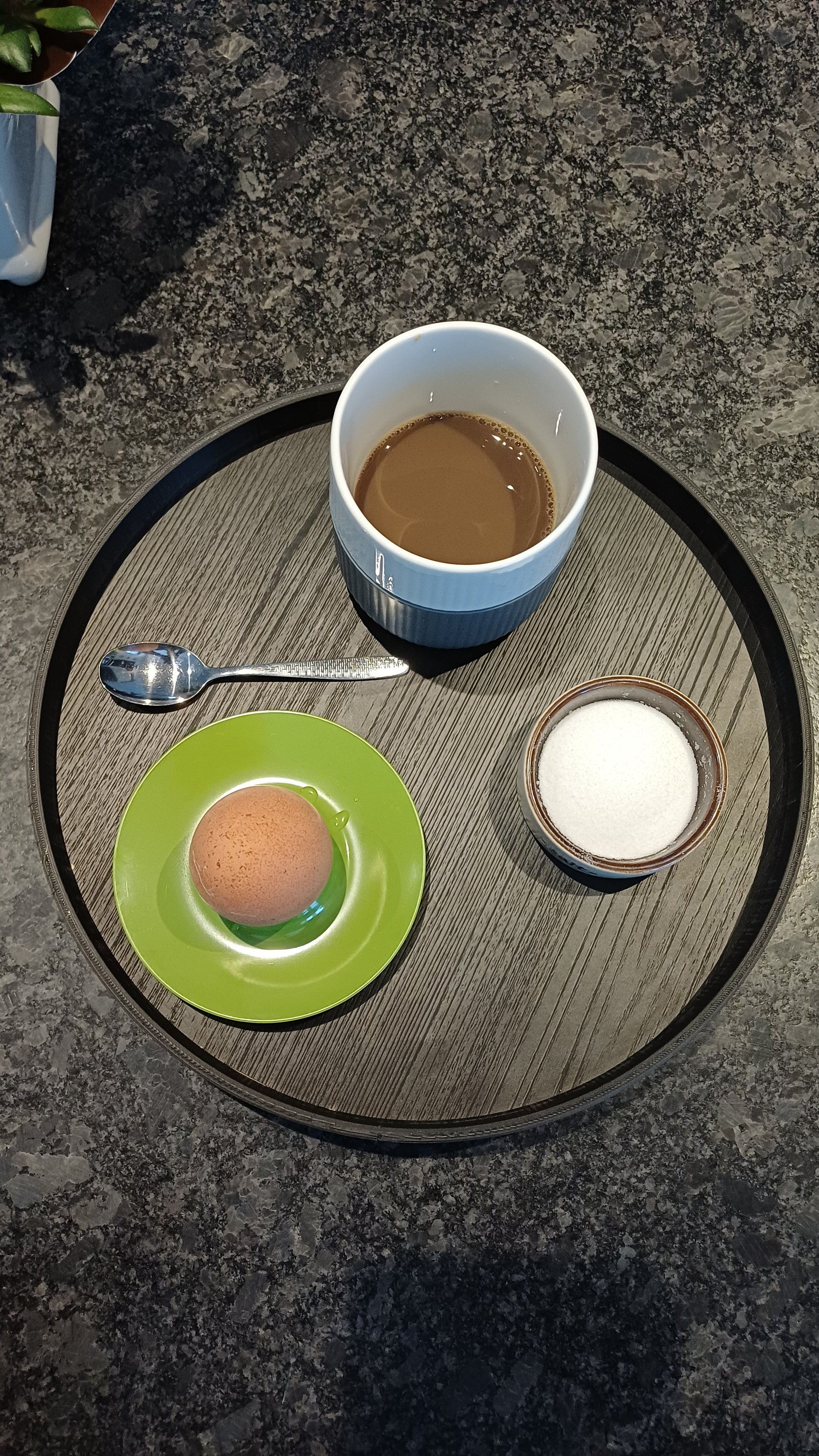 Sort rund 3 D printet ramme, hvori der er lagt en træplade med melaminoverflade, der er afskær fra dansk køkkenproducent. 28 cm i diameter.