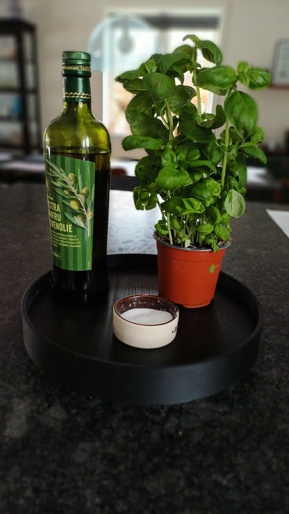 Sort rund 3 D printet ramme, hvori der er lagt en træplade med melaminoverflade, der er afskær fra dansk køkkenproducent. 28 cm i diameter.